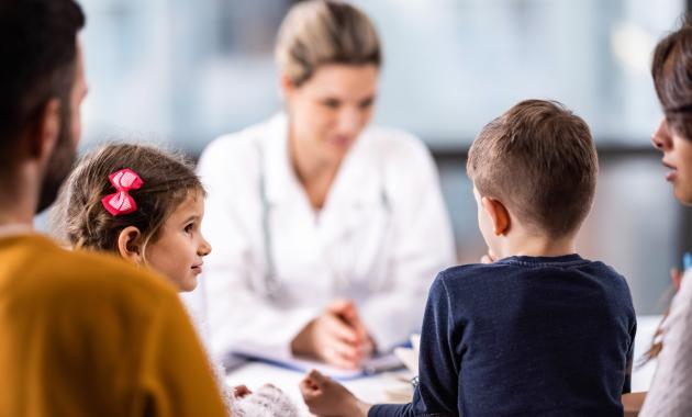 Healthcare professional talking to man and woman with two kids