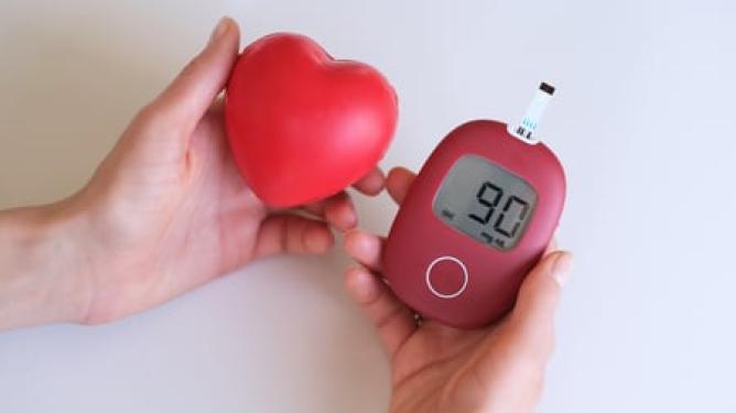 Woman holding blood glucose meter and heart plush